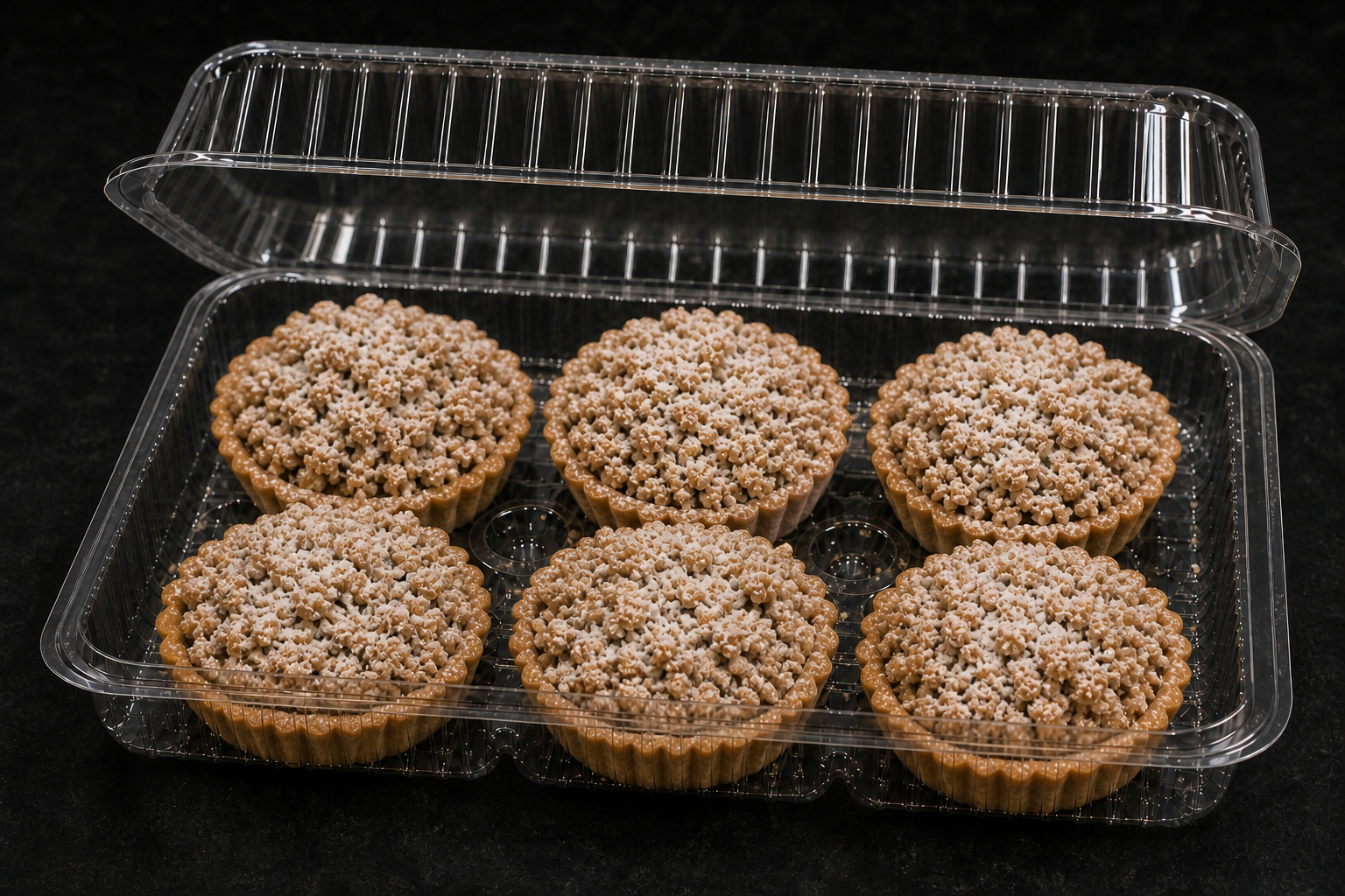 Presentation concept showing six individual apple crumble tarts in clear clamshell packaging