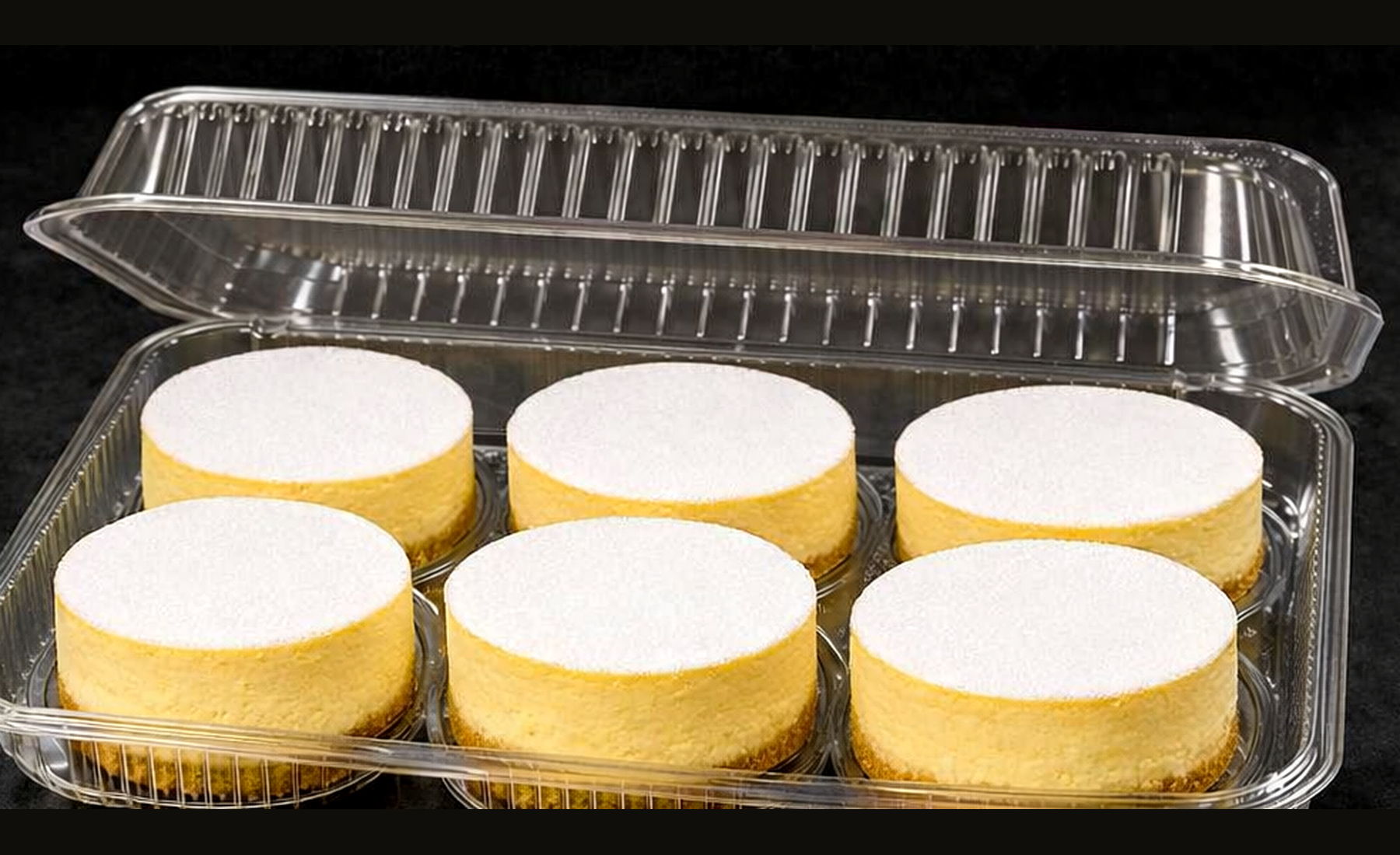 Presentation concept showing six individual baked New York cheesecakes in clear clamshell packaging